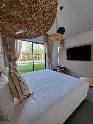 a bedroom with a large bed and a large window at Villa Le Clos de l'Atlas in Marrakech