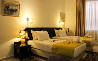 a hotel room with two beds and a lamp at Majorel Pearl Hotel-Riad-Restaurant Piscine&Spa in Marrakech