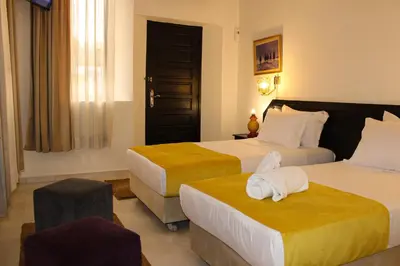 a hotel room with two beds with towels on them at Majorel Pearl Hotel-Riad-Restaurant Piscine&Spa in Marrakech
