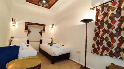 a room with two beds and a lamp in it at RIAD DAR En-Nawat in Marrakech