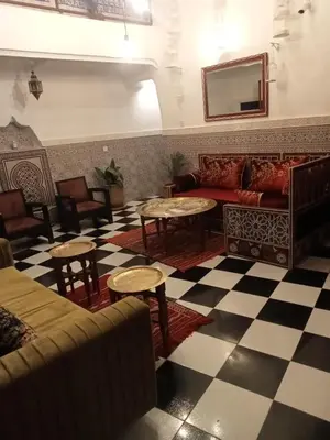 a living room with a couch and tables at Riad l Ayinn in the heart of Marrakech. in Marrakech