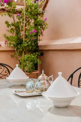 a table with two white dishes and glasses on it at RIAD THE MILESTONE in Marrakech