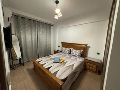 a bedroom with a bed with a tv and a bed sidx sidx sidx at Appartement cosy Gueliz avec piscine in Marrakech