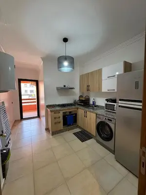 a kitchen with a refrigerator and a dishwasher at Appartement cosy Gueliz avec piscine in Marrakech