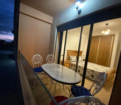 a table and chairs in a room with a bed at Appartement cosy Gueliz avec piscine in Marrakech