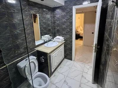a bathroom with a toilet and a sink and a mirror at Al ATLAS résidence in Marrakech