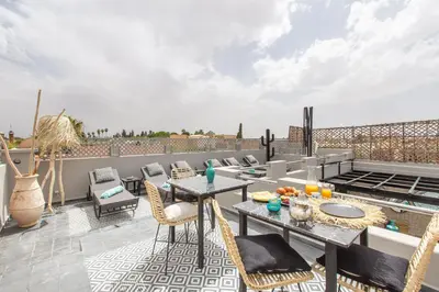 a patio with a table and chairs on a roof at Riad Princesse Des Sables- Jaccuzzi& SPA-Breakfast in Marrakech