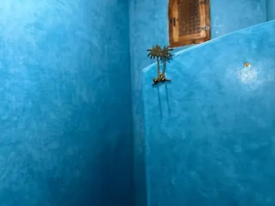 a blue bathroom with a blue wall at Riad Imndi in Marrakech