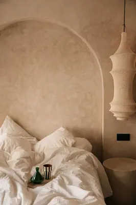 a bed with white sheets and a table with two cups at Riad Nekhla in Marrakech