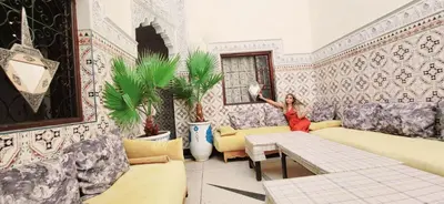 a woman standing in a room with wallpaper at Riad Marrakech Medina in Marrakech