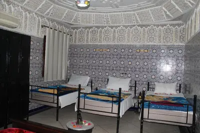 a room with two beds in a room with a wall at Riad Marrakech Medina in Marrakech