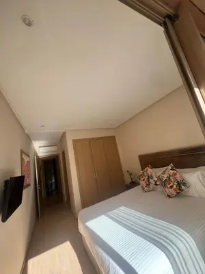 a bedroom with a large bed and a television at Appartement Vue golf Marrakech in Marrakech
