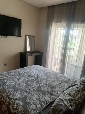 a bedroom with a bed and a television and a window at Appartement Vue golf Marrakech in Marrakech