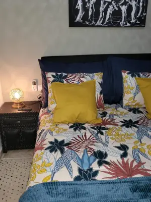 a bed with a colorful comforter and two pillows at Atlas golf rossort in Marrakech