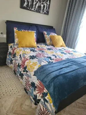 a bed with a colorful comforter and pillows at Atlas golf rossort in Marrakech