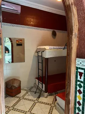 a room with two bunk beds and a mirror at Riad Elijah Marrakech & SPA in Marrakech
