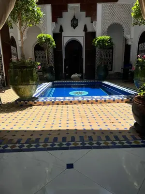 a swimming pool in a building with a tile floor at Riad Malida Marrakech in Marrakech