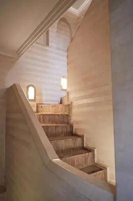 a staircase in a building with a stone wall at Riad Al Ibtikar in Marrakech