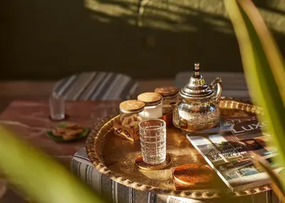 a table with a tray of food and a tea kettle at Riad Al Ibtikar in Marrakech