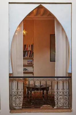 a balcony with a table and a book shelf at Riad Al Ibtikar in Marrakech