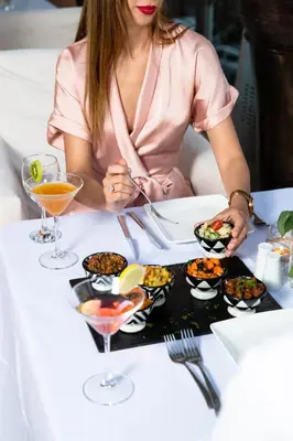 a woman sitting at a table with a plate of food at Riad Wow in Marrakech
