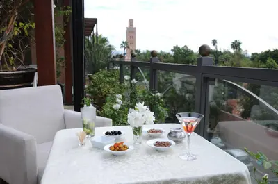 a white table with food and drinks on a balcony at Riad Wow in Marrakech