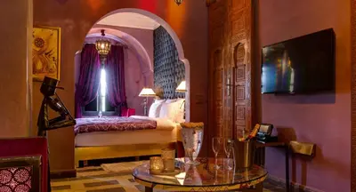 a bedroom with a bed and a table in a room at Riad Wow in Marrakech