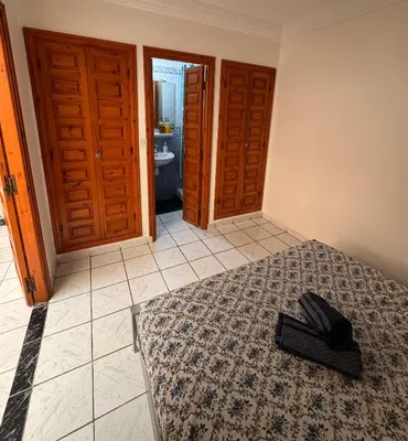 a bedroom with a bed with a hat on it at Riad Naïel 3 piscines in Marrakech