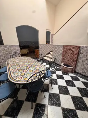 a room with a table and chairs on a checkered floor at Riad Naïel 3 piscines in Marrakech