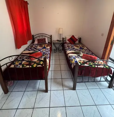 two twin beds in a room with a tiled floor at Riad Naïel 3 piscines in Marrakech