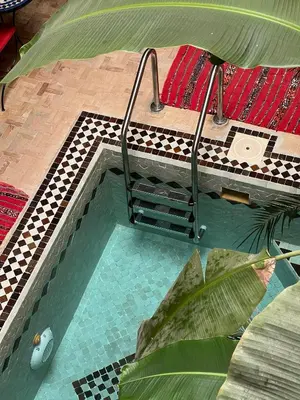 an overhead view of a swimming pool with a table at Riad Hugo in Marrakech