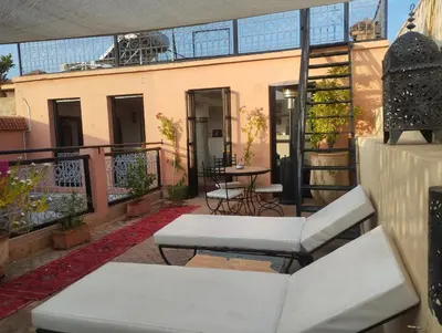 a patio with a table and chairs on a balcony at Riad Hugo in Marrakech