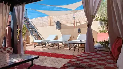 a patio with chairs and a table and a staircase at Riad Hugo in Marrakech