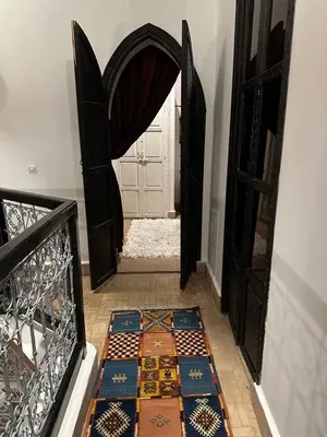 a hallway with an open door with a tile floor at Riad Hugo in Marrakech