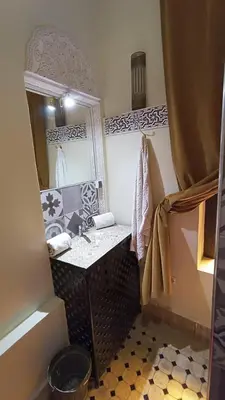 a bathroom with a sink and a mirror at Riad Hugo in Marrakech
