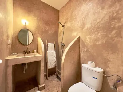 a bathroom with a toilet and a sink and a mirror at Riad La Rose Des Sables in Marrakech