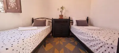 two twin beds in a room withthritisthritisthritisthritisthritisthritisthritisthritisthritis at Hostel Kech Vibe in Marrakech