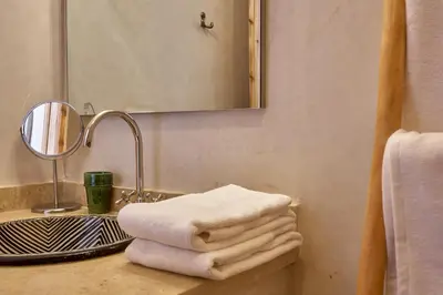 a bathroom with a sink with towels on a counter at Ryad Selyen in Marrakech