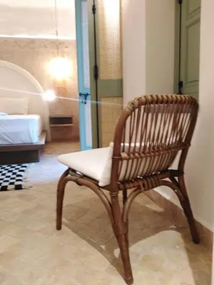 a wooden chair with a white seat in a room at Riad Lalla Mimouna in Marrakech