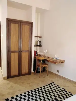 a room with a desk and a wooden cabinet at Riad Lalla Mimouna in Marrakech