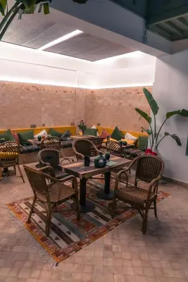 a room with a table and chairs and a couch at Riad Lalla Mimouna in Marrakech