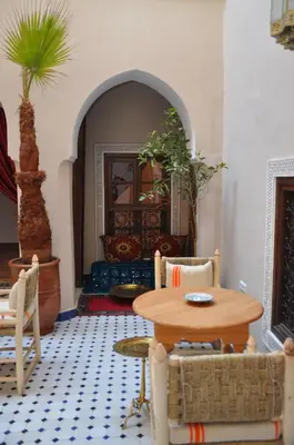 a living room with a table and chairs at Dar Aouinti in Marrakech