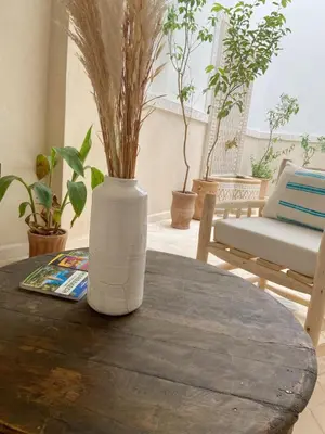 a white vase sitting on top of a wooden table at Riad21 in Marrakech