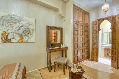 a bedroom with a bed and a desk and a door at Palais Tara & Spa in Marrakech
