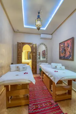 two twin beds in a room with a mirror at Palais Tara & Spa in Marrakech