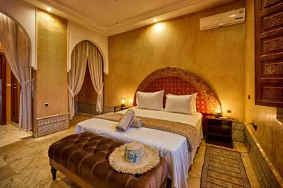 a hotel room with a large bed and a bench at Villa Taj Sofia & Spa in Marrakech