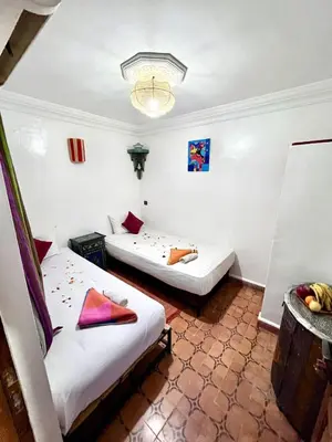 a room with two beds and a chandelier at RIAD TENDANCE IN MARRAKECH in Marrakech