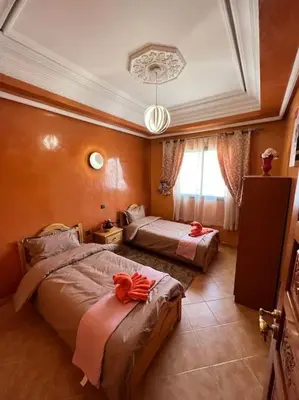 a hotel room with two beds and a window at Superbe appartement avec parking gratuit in Marrakech