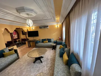 a living room with blue couches and a table at Superbe appartement avec parking gratuit in Marrakech