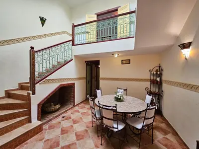 a dining room with a table and a staircase at Duplex el Madina in Marrakech